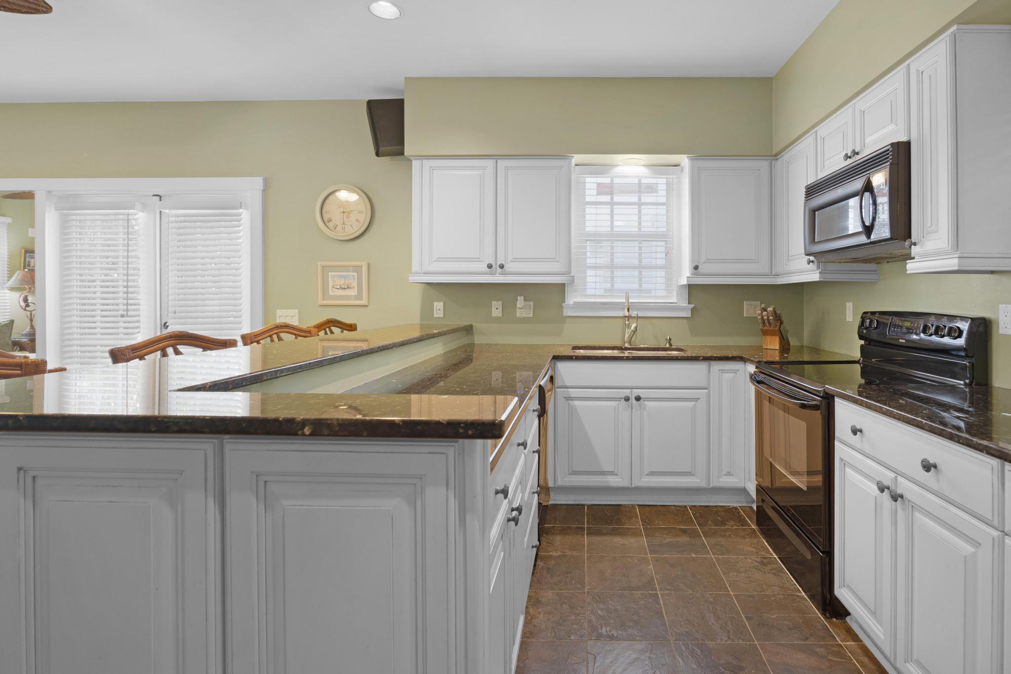 606 Truman Avenue, Unit 10 Key West, FL 33040 - Photo 7 of 20 a kitchen with granite countertop a sink and cabinets