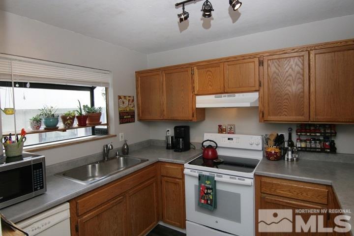 a kitchen with stainless steel appliances granite countertop a sink a stove and a refrigerator