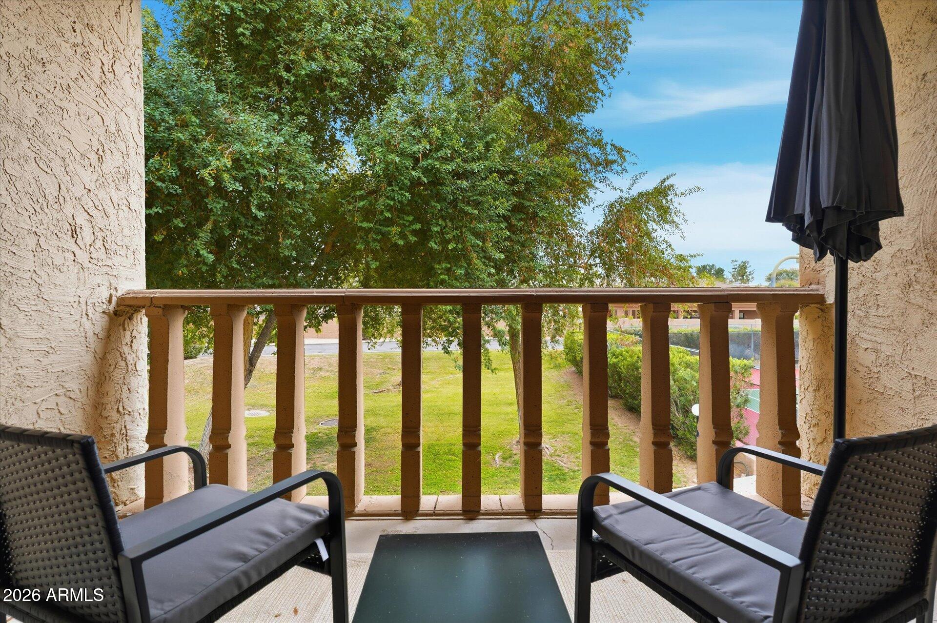 8649 East Royal Palm Road, Unit 239 Scottsdale, AZ 85258 - Photo 26 of 34 a view of a balcony with wooden floor and outdoor seating