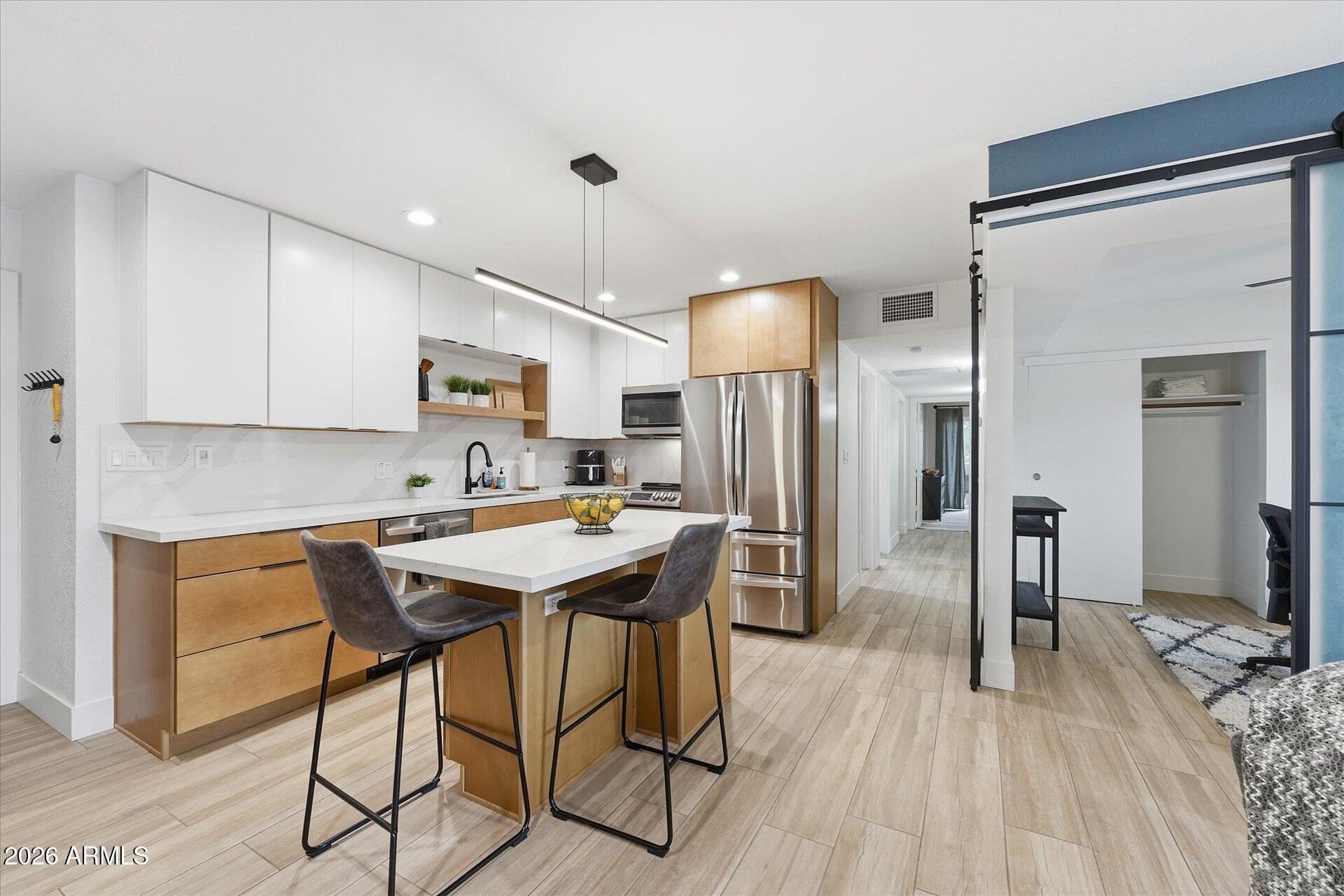 8649 East Royal Palm Road, Unit 239 Scottsdale, AZ 85258 - Photo 6 of 34 a kitchen with stainless steel appliances a dining table chairs refrigerator and stove top oven
