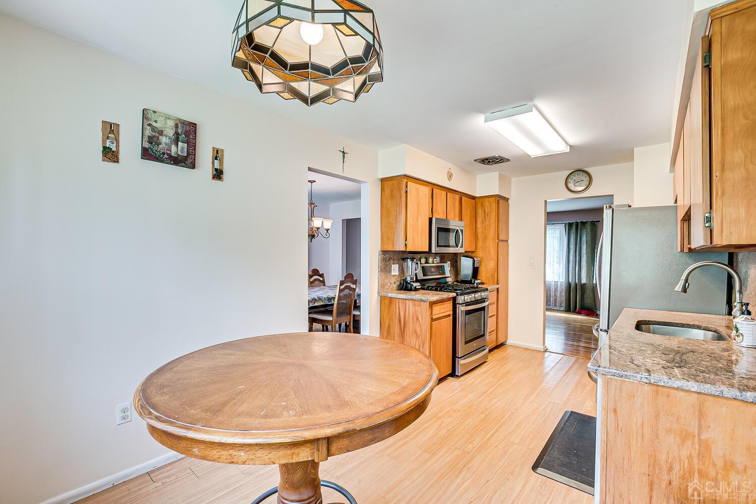 2 Julie Drive Edison, NJ 08820 - Photo 14 of 34 a kitchen with stainless steel appliances granite countertop a sink dishwasher and a stove with wooden floor