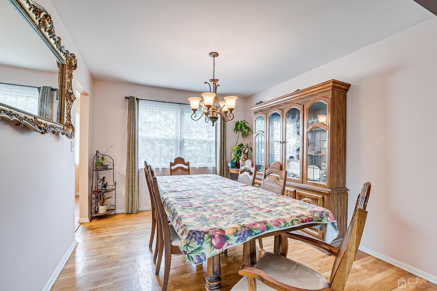 2 Julie Drive Edison, NJ 08820 - Photo 8 of 34 a dining room with wooden floor a chandelier a wooden table and chairs