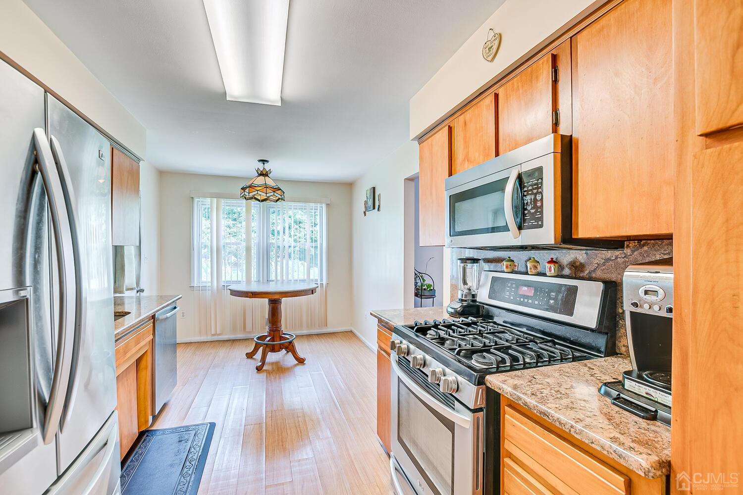 2 Julie Drive Edison, NJ 08820 - Photo 9 of 34 a kitchen with a stove a sink and a wooden floor