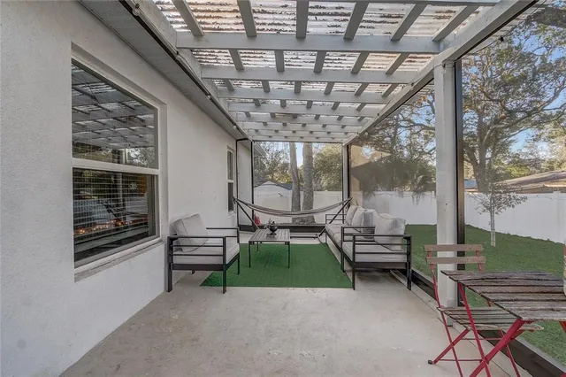 a living room with patio furniture and a floor to ceiling window