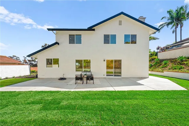 a front view of a house with a garden and outdoor seating