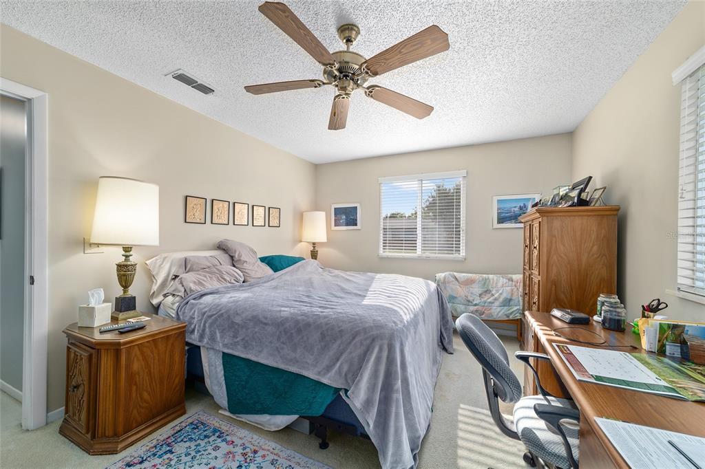 10921 Southwest 86th Court Ocala, FL 34481 - Photo 25 of 51 a bedroom with a bed a window and a chandelier