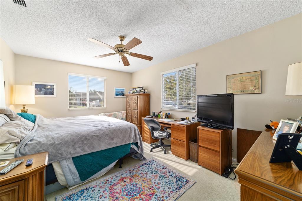 10921 Southwest 86th Court Ocala, FL 34481 - Photo 26 of 51 a bedroom with a bed and a flat screen tv