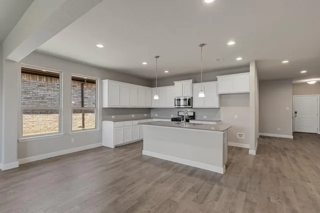 a kitchen with stainless steel appliances granite countertop a stove a sink and a refrigerator