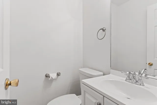 a bathroom with a sink mirror vanity and toilet