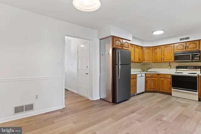 a kitchen with a refrigerator a stove top oven a sink and dishwasher