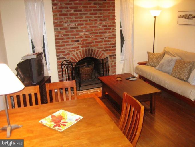 220 13th Street Southeast, Unit 5 Washington, DC 20003 - Photo 3 of 17 a living room with furniture a fireplace and a dining table with wooden floor