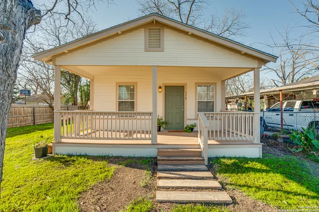 a view of a house with a small yard and wooden floor and fence