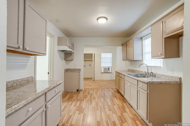a kitchen with granite countertop a sink stove and refrigerator