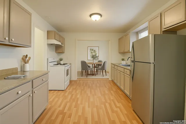 a kitchen with cabinets and wooden floor