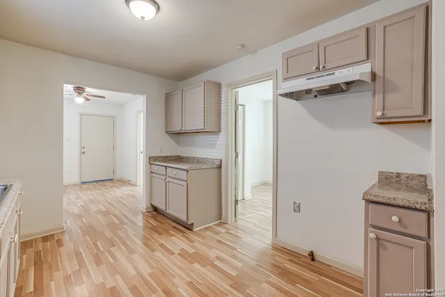 a kitchen with granite countertop a refrigerator and a stove top oven