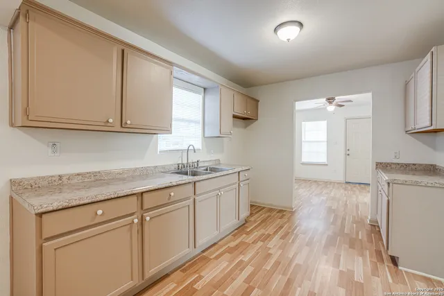 a kitchen with granite countertop white cabinets and white appliances