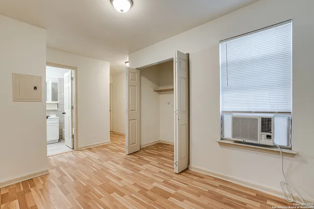 a view of a livingroom with wooden floor and a bathroom