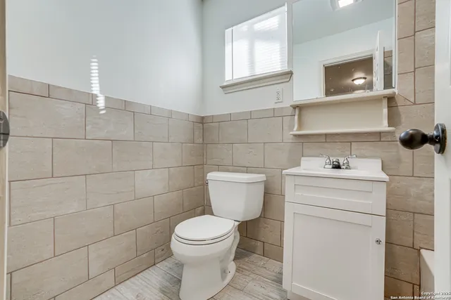 a bathroom with a toilet sink and mirror