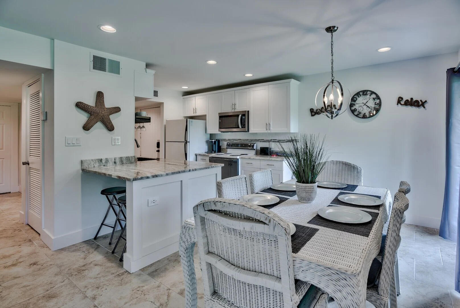 159 Sunset Bay, Unit 23A Miramar Beach, FL 32550 - Photo 12 of 31 a kitchen with granite countertop a table chairs stove and microwave