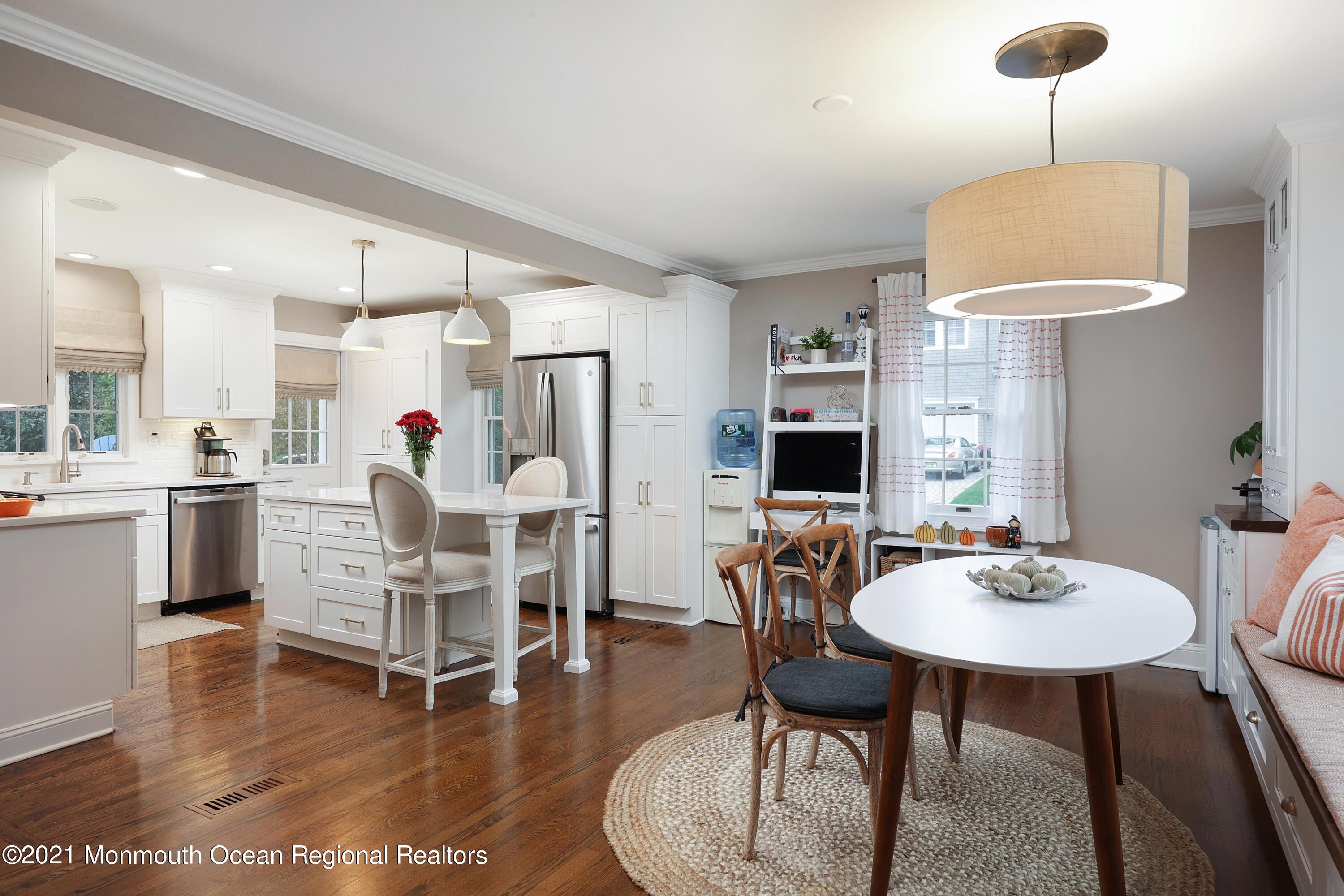 57 River Road Rumson, NJ 07760 - Photo 4 of 34 a dining room with wooden floor a chandelier a glass table and chairs