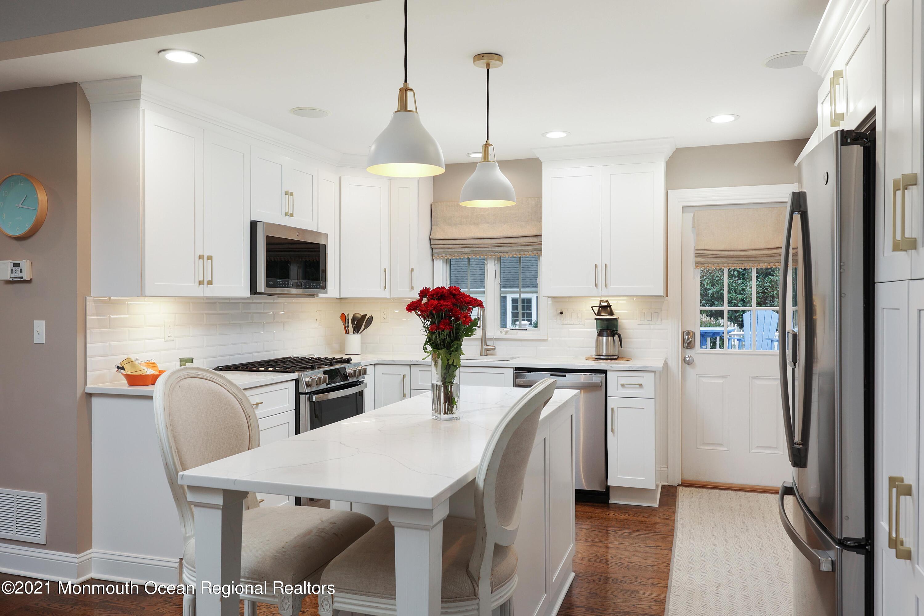 57 River Road Rumson, NJ 07760 - Photo 8 of 34 a kitchen with stainless steel appliances granite countertop a stove a refrigerator a oven a sink with a dining table and chairs