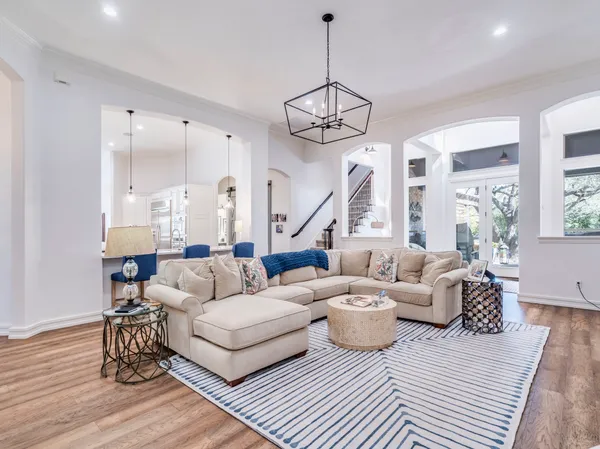 a living room with furniture chandelier and a table