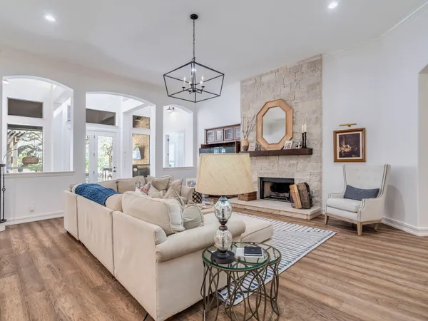 a living room with furniture a fireplace and a chandelier