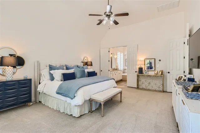 a spacious bedroom with a bed and ceiling fan