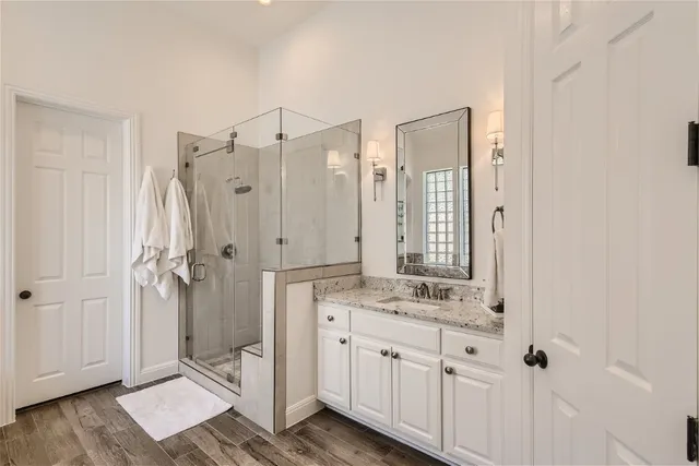 a bathroom with a granite countertop sink mirror and shower