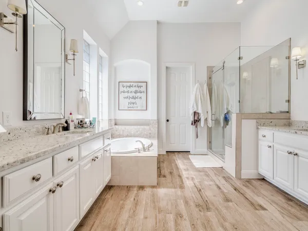 a spacious bedroom with a large bed and a flat tv screen on dresser