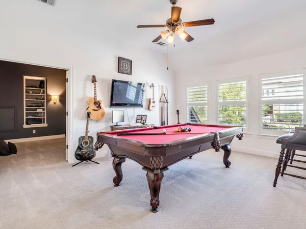 a room with pool table and windows