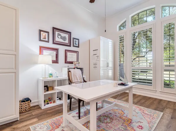 a view of a workspace with furniture and a window