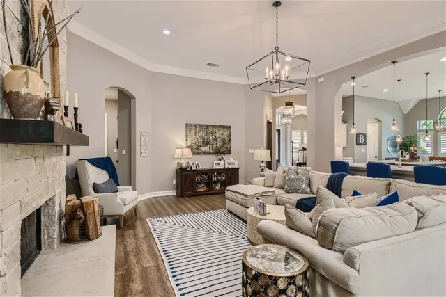 a living room with furniture a chandelier and a flat screen tv
