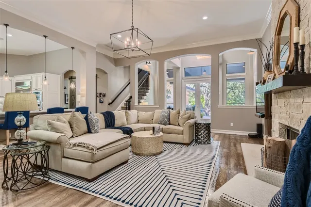 a living room with furniture a fireplace and a chandelier