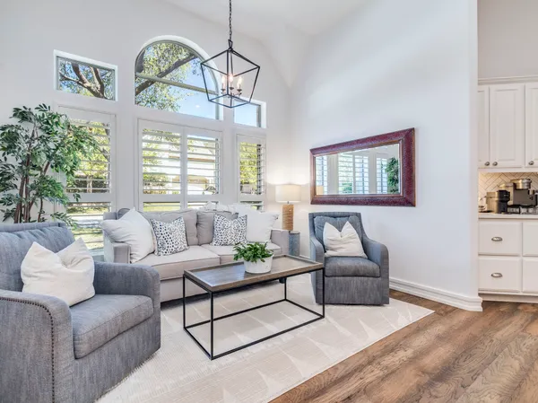 a living room with furniture chandelier and a large window