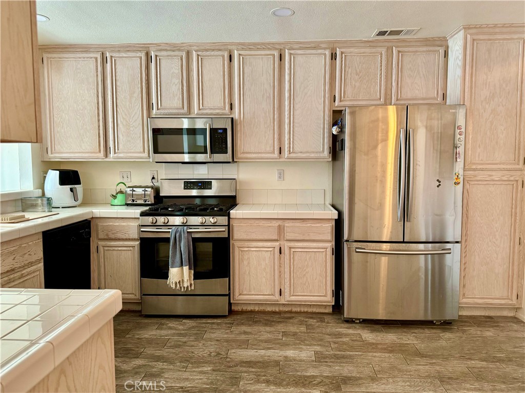 2275 Indigo Hills Drive, Unit 4 Corona, CA 92879 - Photo 2 of 9 a kitchen with cabinets stainless steel appliances and a window