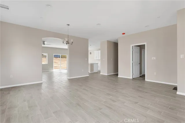 a view of a big room with wooden floor and windows