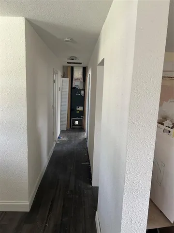a view of a hallway with wooden floor and windows