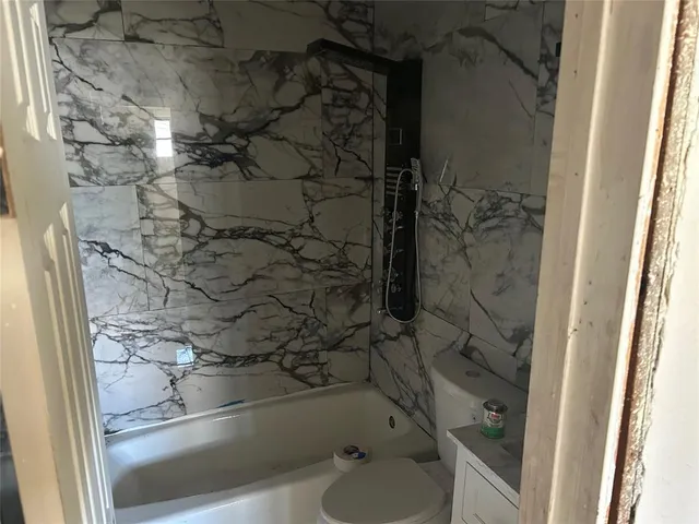 a bathroom with a glass shower door and a sink