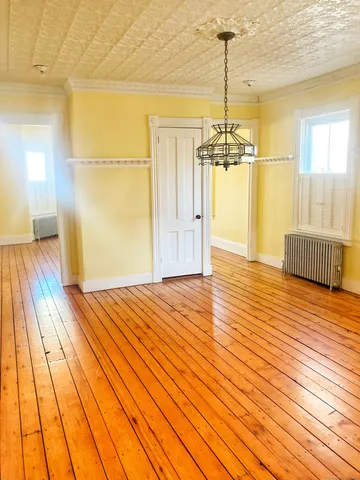 a view of a room with wooden floor windows and chandelier