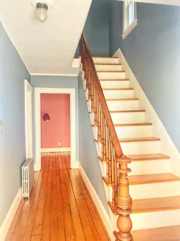 a view of entryway and hall with wooden floor