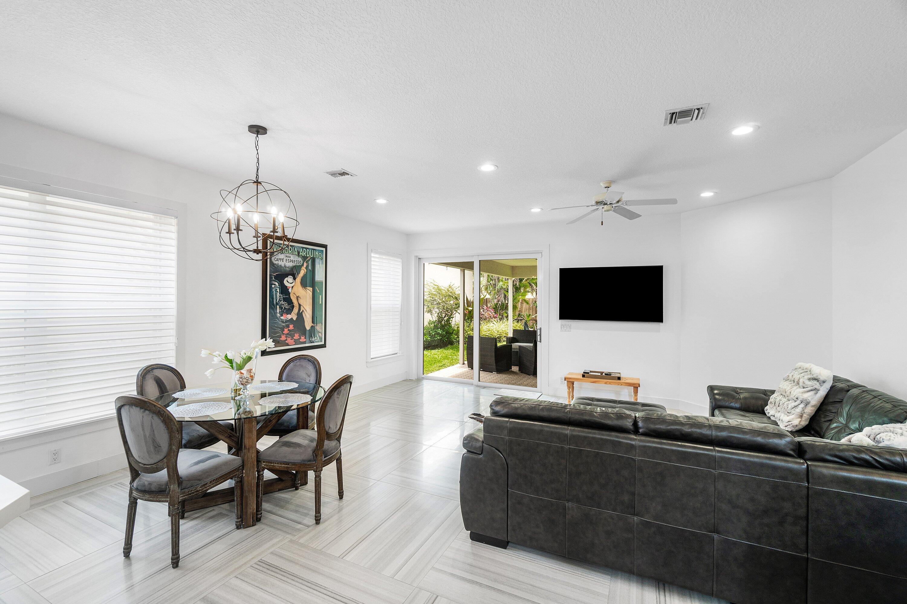 2404 Northwest 67th Street Boca Raton, FL 33496 - Photo 13 of 74 a living room with furniture and a flat screen tv