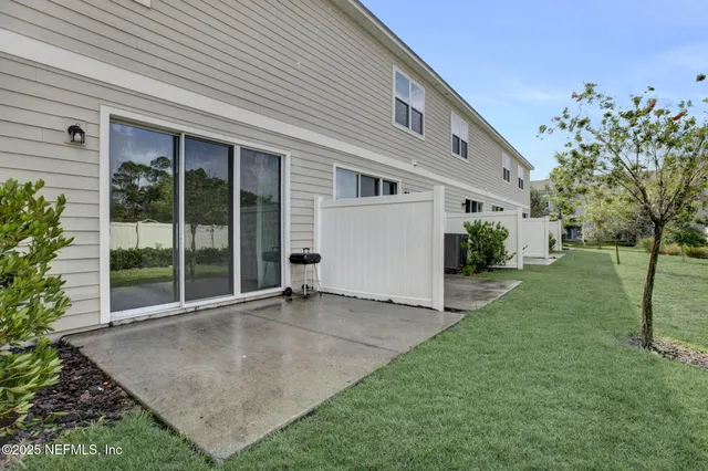 a front view of a house with a yard and potted plants