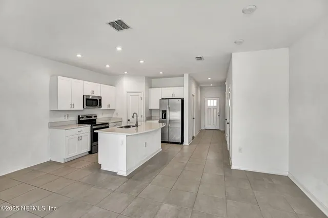 a kitchen with white cabinets and stainless steel appliances