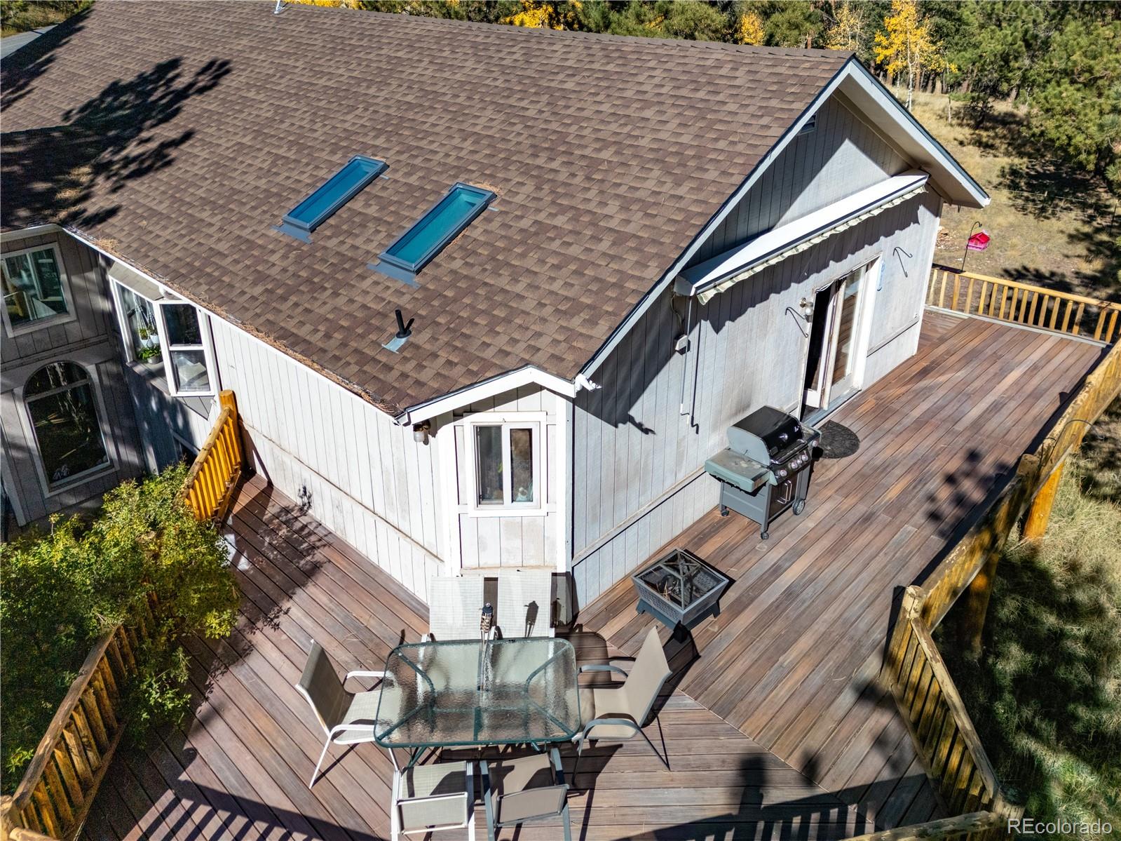 a view of a house with wooden deck and furniture