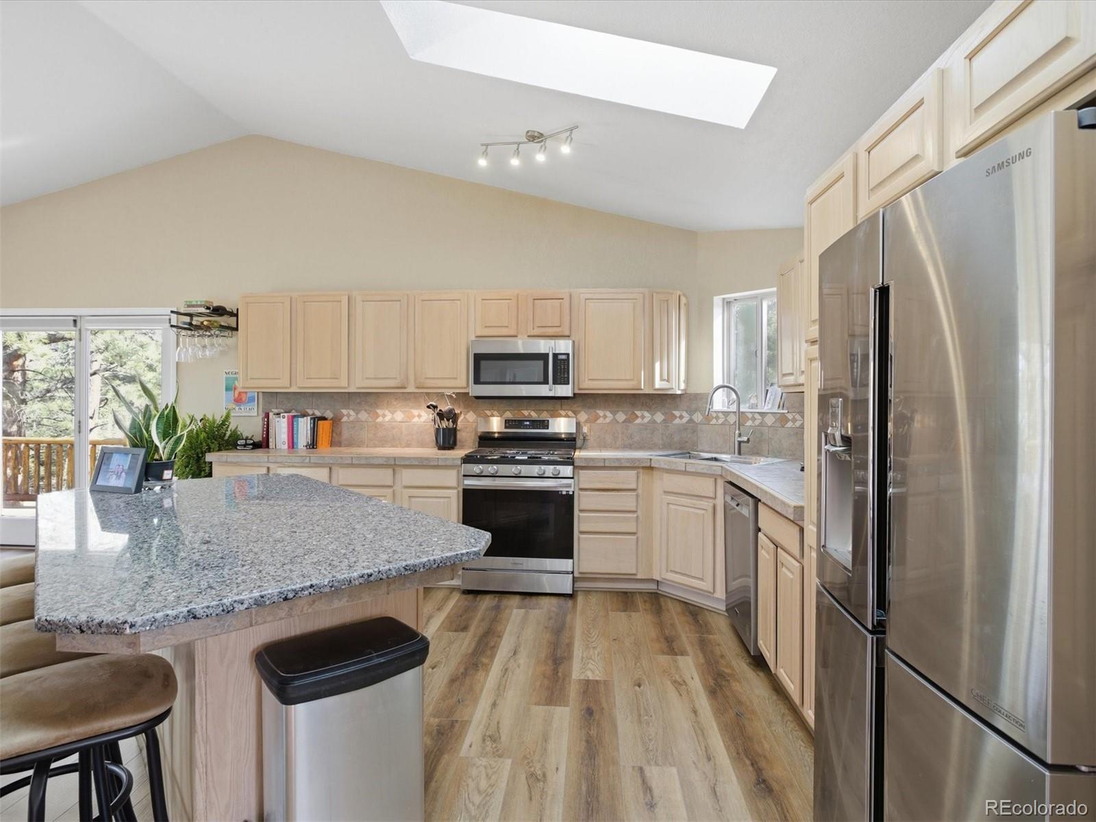 209 Pine Drive Bailey, CO 80421 - Photo 11 of 48 a kitchen with granite countertop stainless steel appliances a refrigerator a stove a sink and a center island