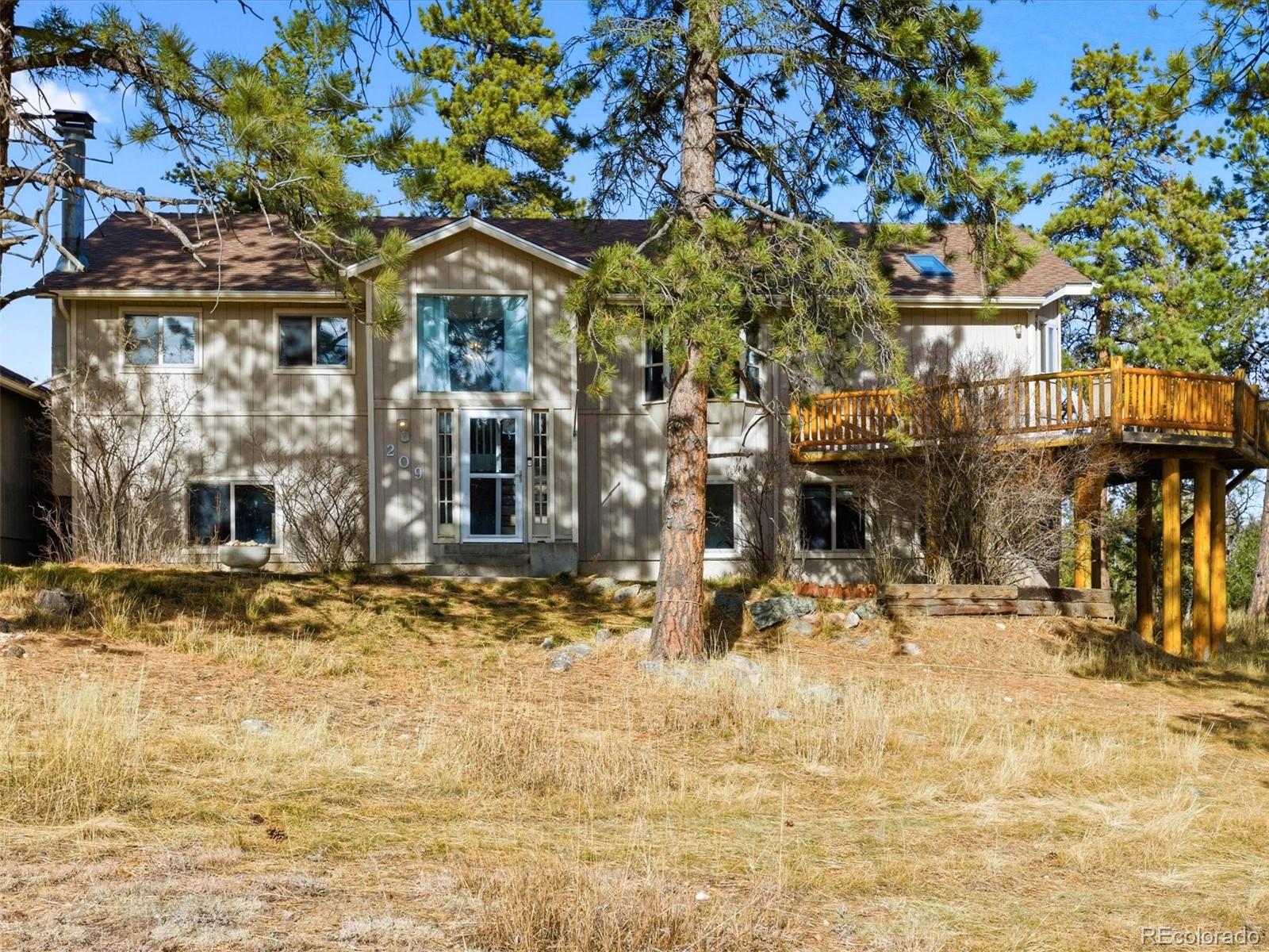 209 Pine Drive Bailey, CO 80421 - Photo 5 of 48 a front view of a building with a garden