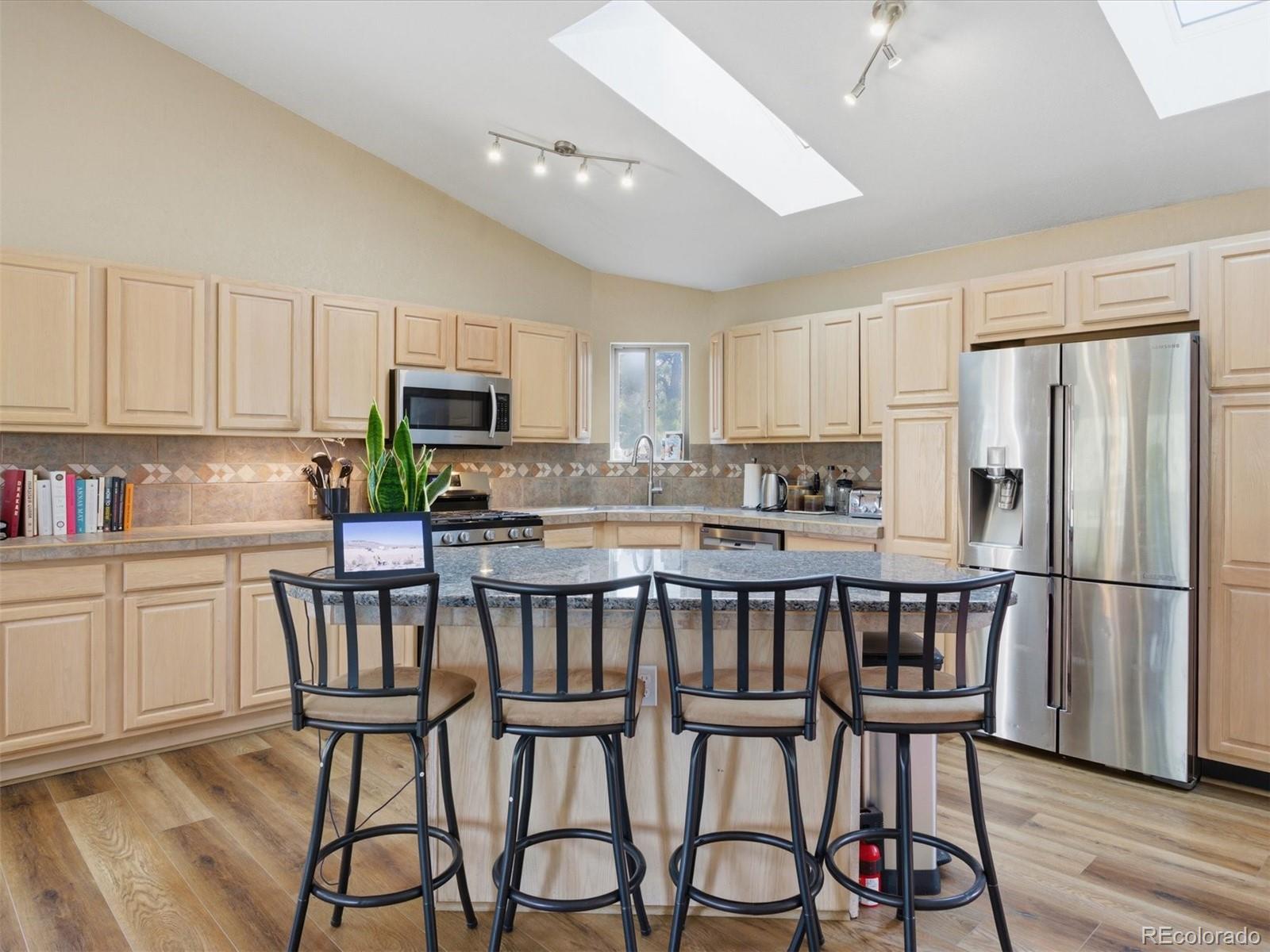 209 Pine Drive Bailey, CO 80421 - Photo 8 of 48 a kitchen with stainless steel appliances a dining table chairs microwave and sink