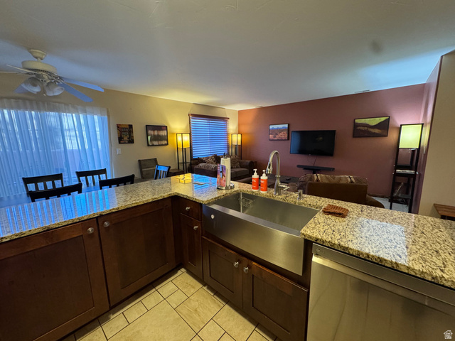 3439 Westwater Road Moab, UT 84532 - Photo 60 of 64 Kitchen with dark brown cabinets, light stone counters, dishwasher, open floor plan, and ceiling fan