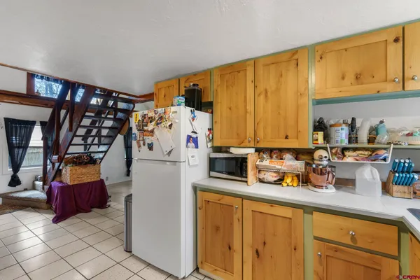 a view of kitchen with stainless steel appliances granite countertop a refrigerator and cabinets